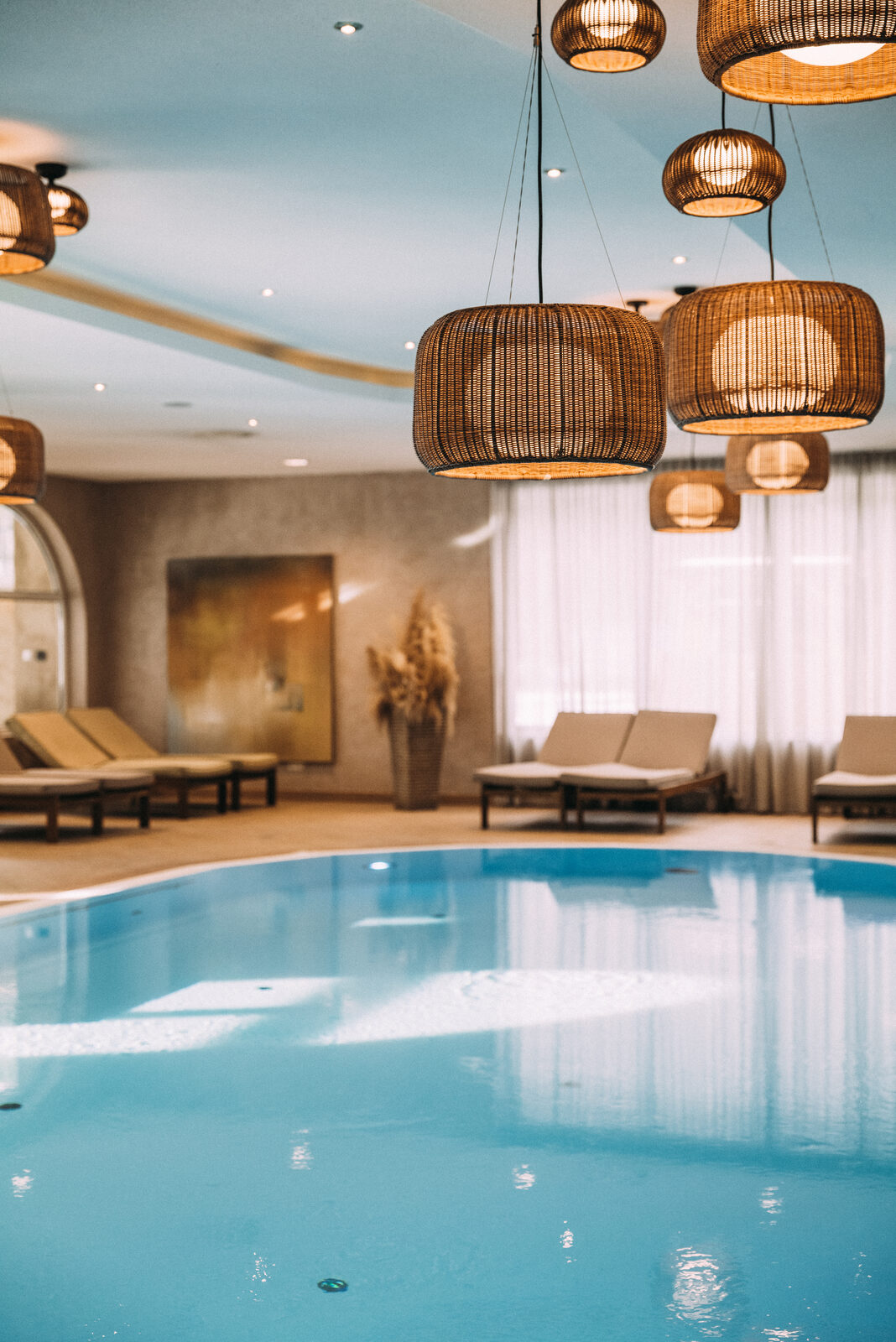 Indoor pool at POST under rattan pendant lights.