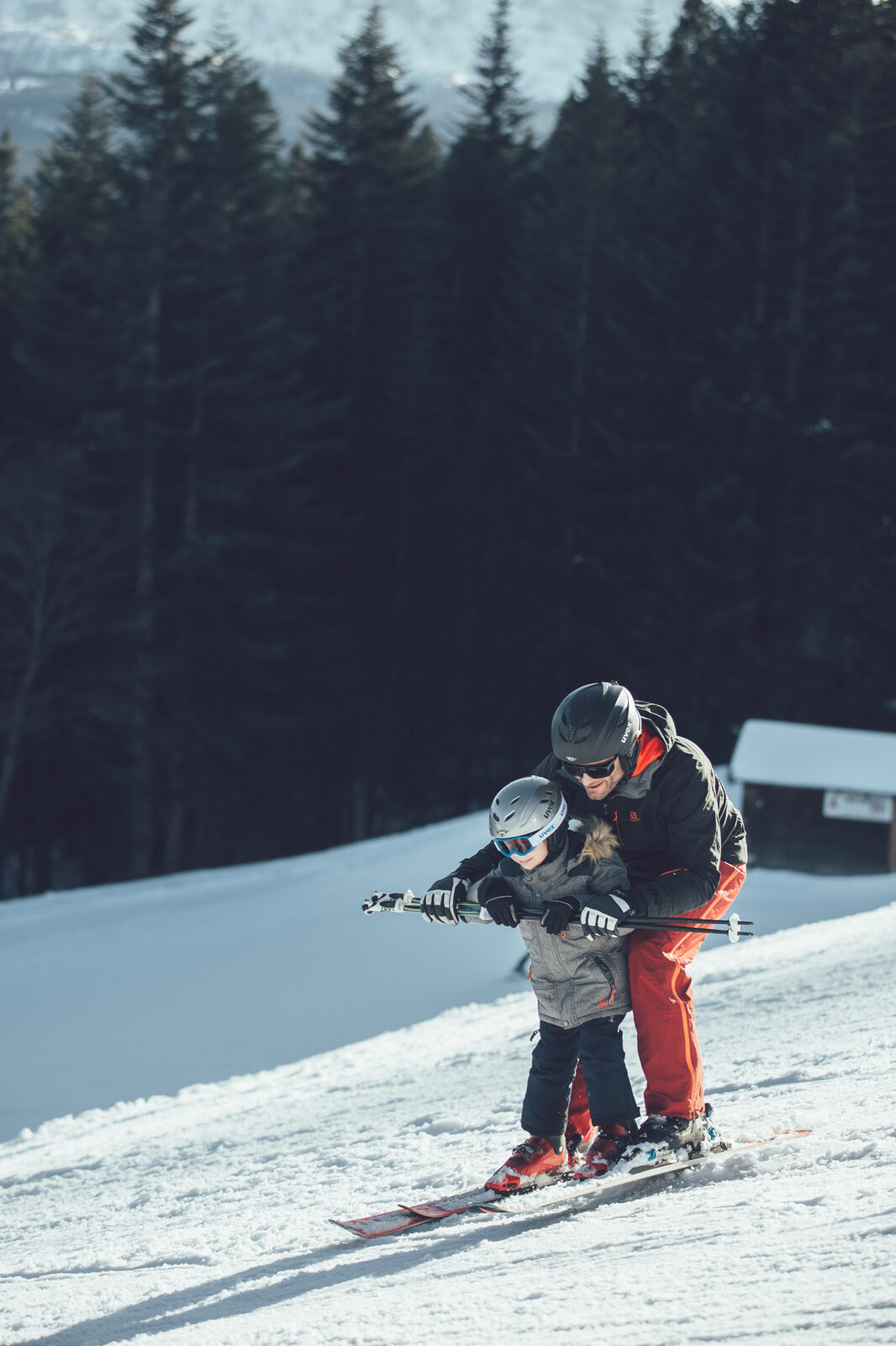 Father teaches his child to ski on a quiet piste.
